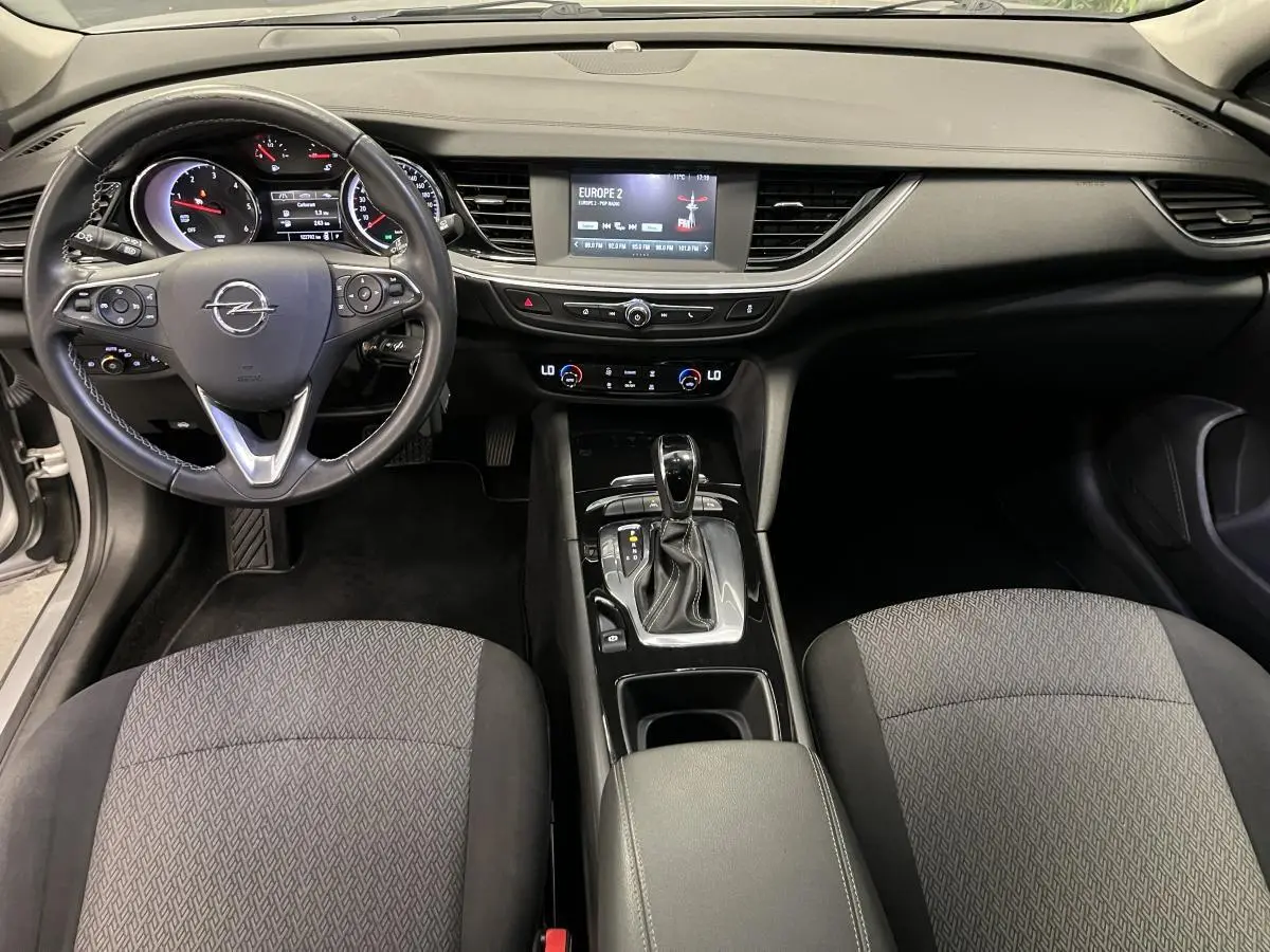 Intérieur Opel Insignia Sports Tourer 2020 vu de face, tableau de bord noir avec écran tactile et sièges tissu gris anthracite.