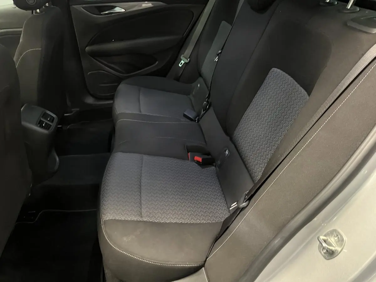 Vue côté droit de la banquette arrière tissu anthracite de l'Opel Insignia Sports Tourer gris avec ceintures de sécurité visibles.