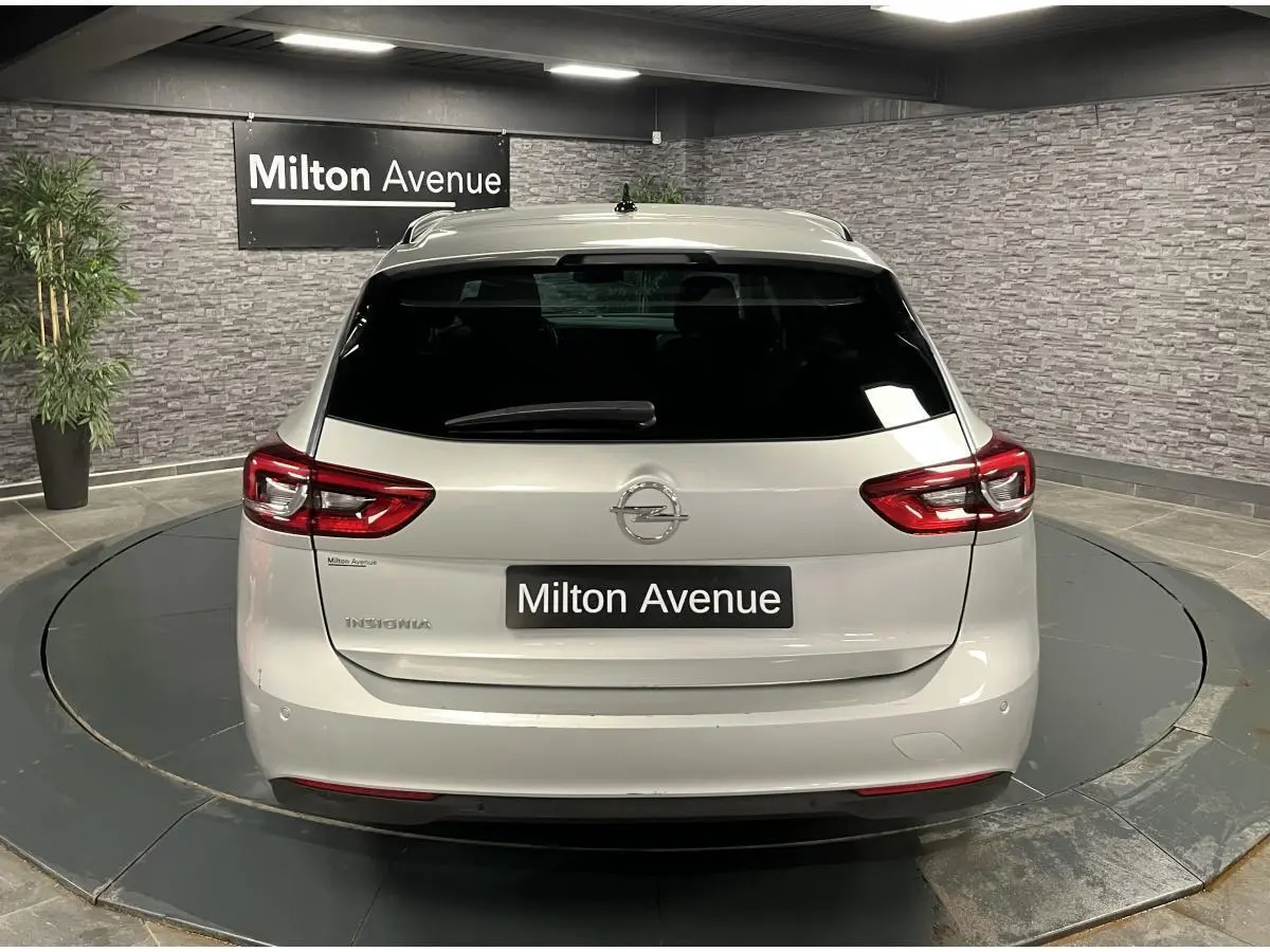 Vue arrière d'une Opel Insignia Sports Tourer gris métallisé avec feux arrière LED et lunette arrière surteintée.