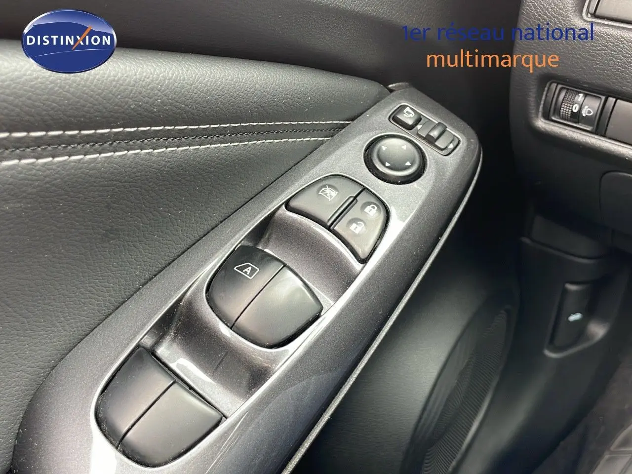 Gros plan sur les commandes de fenêtre et rétroviseurs côté conducteur d'un Nissan Juke gris perle 2023.