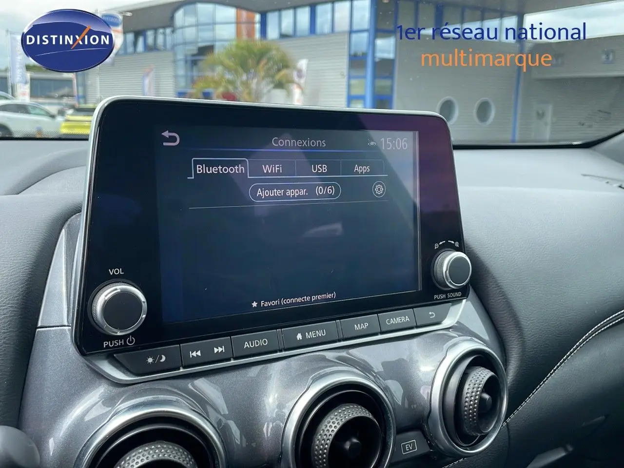 Écran tactile central avec options Bluetooth, WiFi et USB sur tableau de bord gris perle métal d'un Nissan Juke Hybrid 2023.