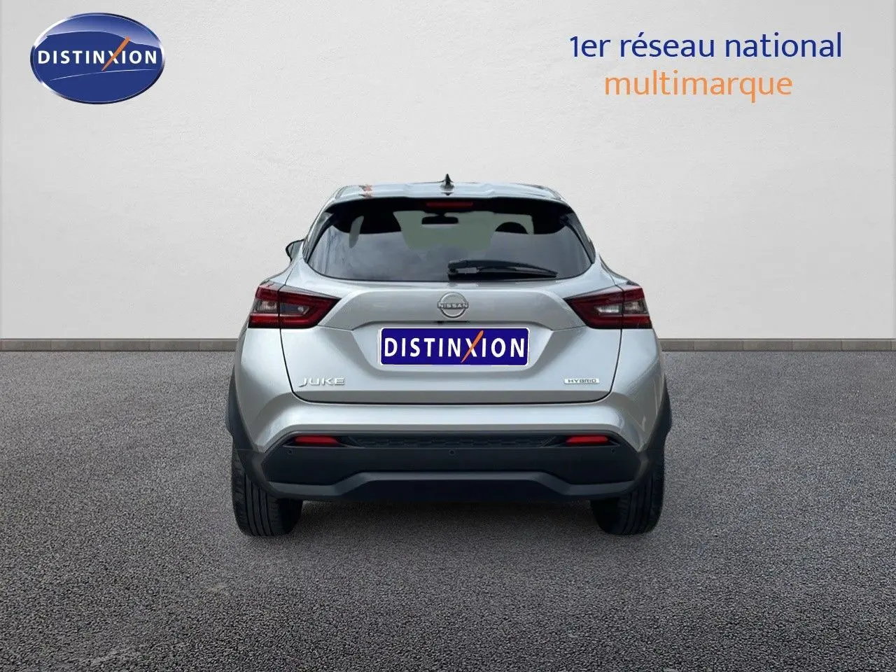 Vue arrière d'un Nissan Juke Hybrid gris perle métal, mettant en valeur ses feux LED et son design compact.