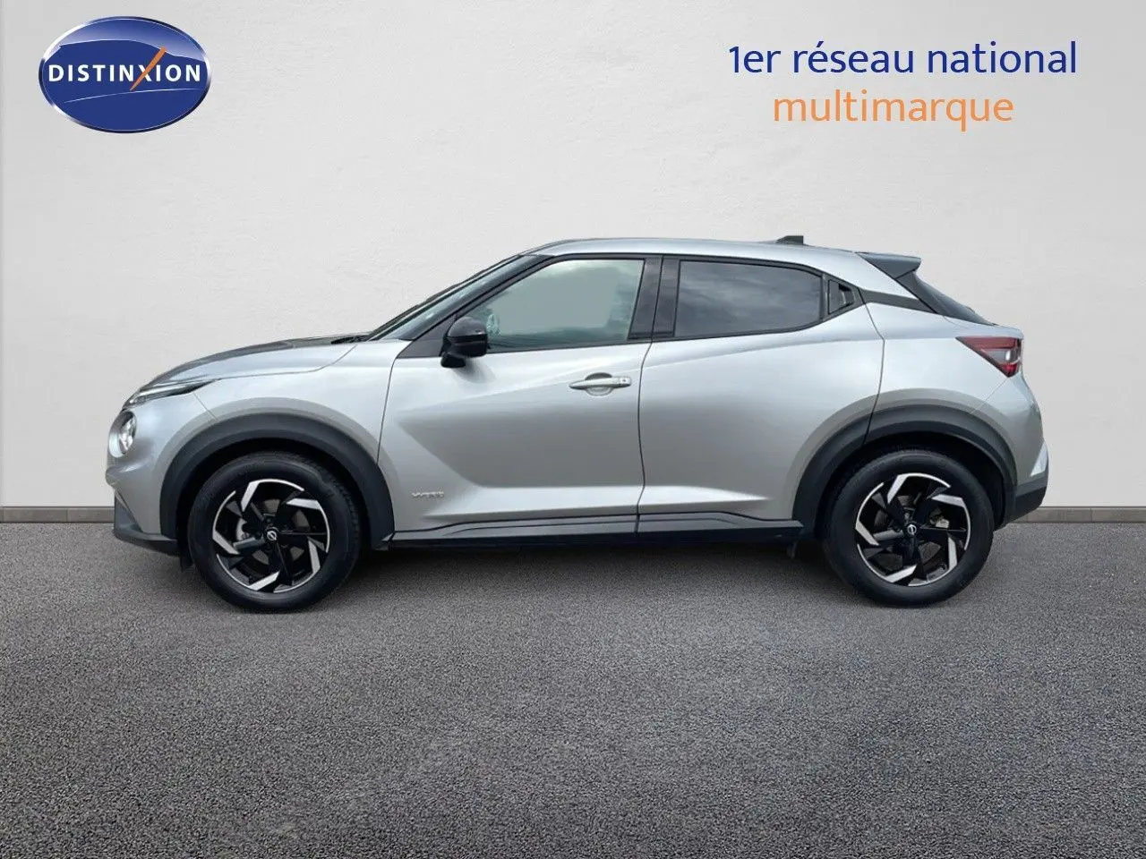 Profil côté gauche du Nissan Juke Hybrid 143ch Business gris perle métallisé avec jantes noires et toit contrasté noir.