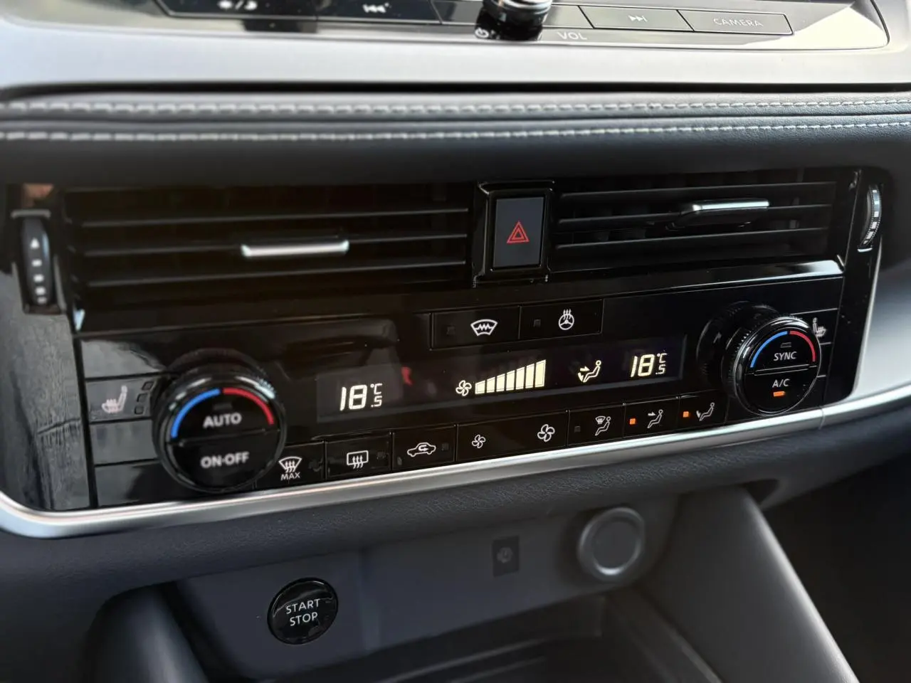 Détail du tableau de bord noir du Nissan Qashqai blanc nacré 2025, affichage numérique de la climatisation bi-zone.