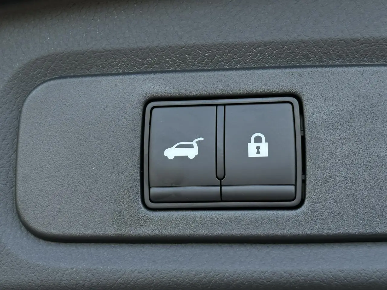 Boutons d'ouverture électrique du hayon et de verrouillage sur panneau intérieur du Nissan Qashqai blanc nacré.