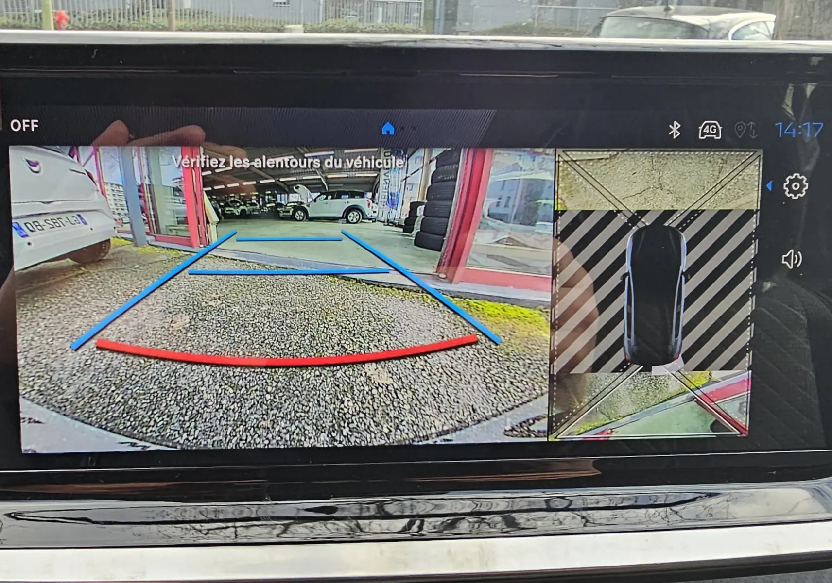 Écran de caméra de recul du Peugeot 208 gris montrant l’arrière du véhicule et l’aide au stationnement en vue 3D.