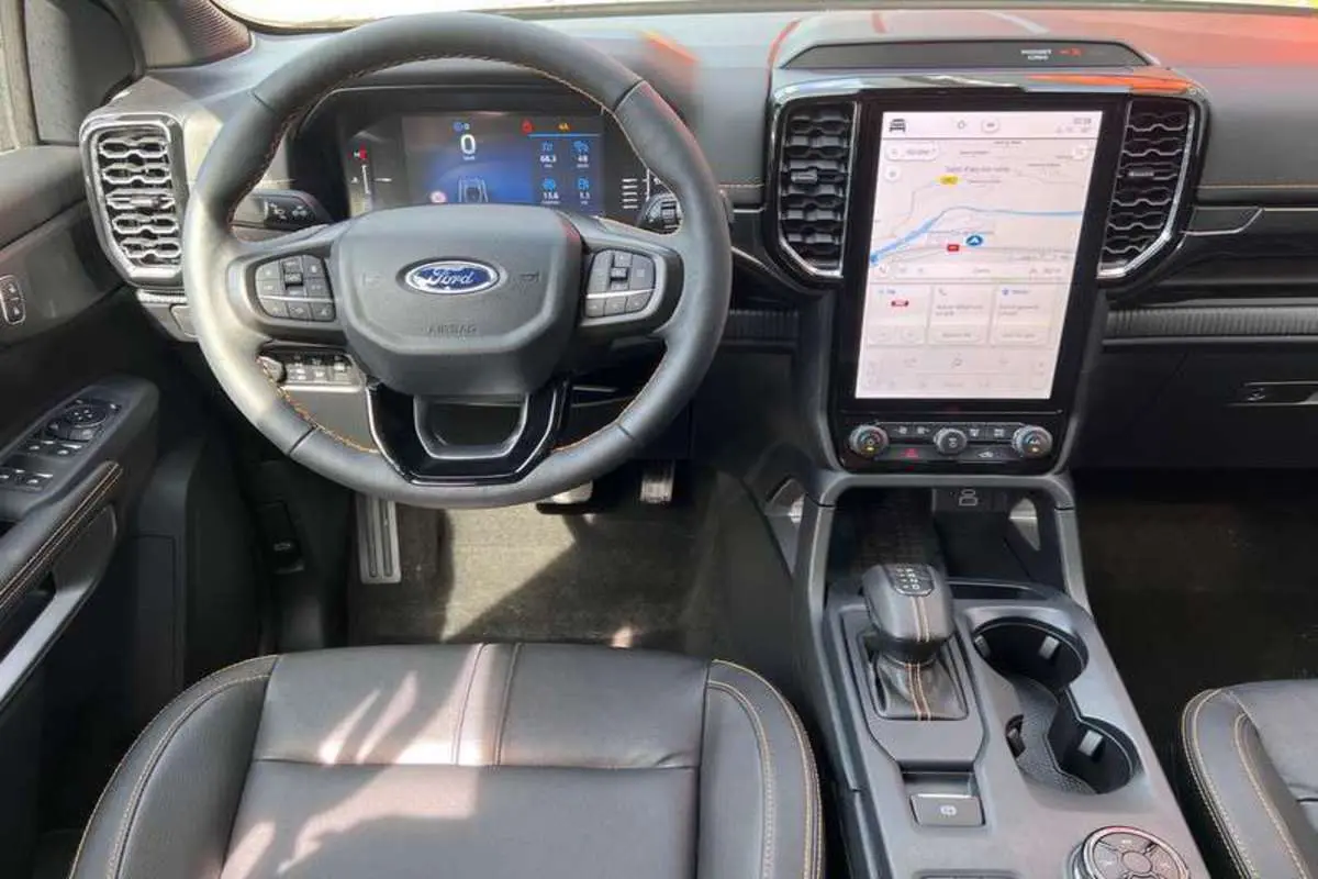 Vue intérieure du tableau de bord du Ford Ranger 2025, volant cuir multifonctions et écran tactile vertical.