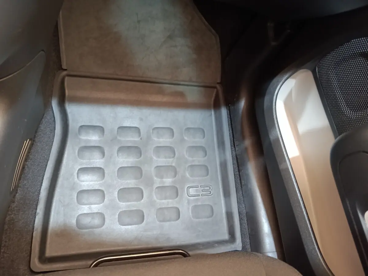 Tapis de sol avant côté conducteur noir avec logo C3 dans l’habitacle d’une Citroën C3 blanche.