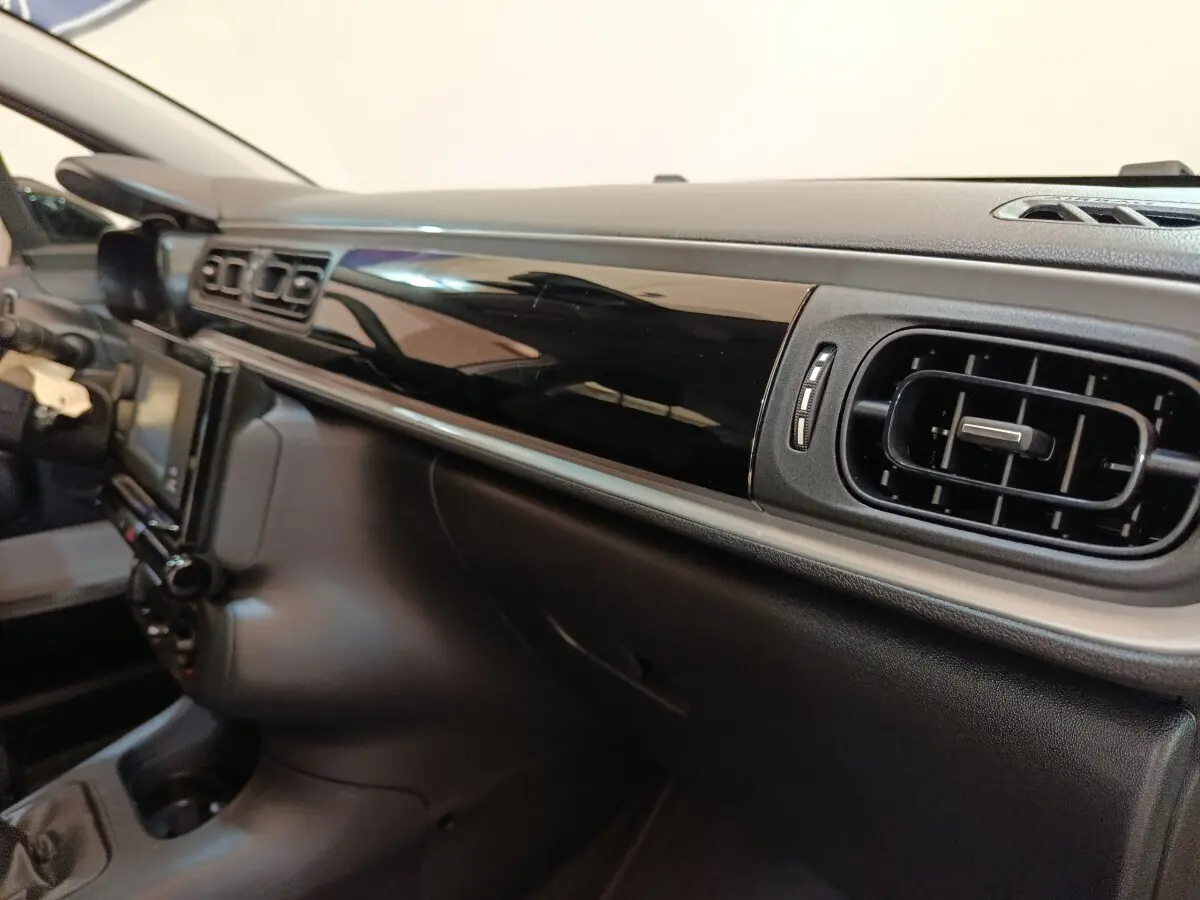 Vue intérieure du tableau de bord noir brillant côté passager de la Citroën C3 BlueHDi 100 S&S BVM Feel 2021.