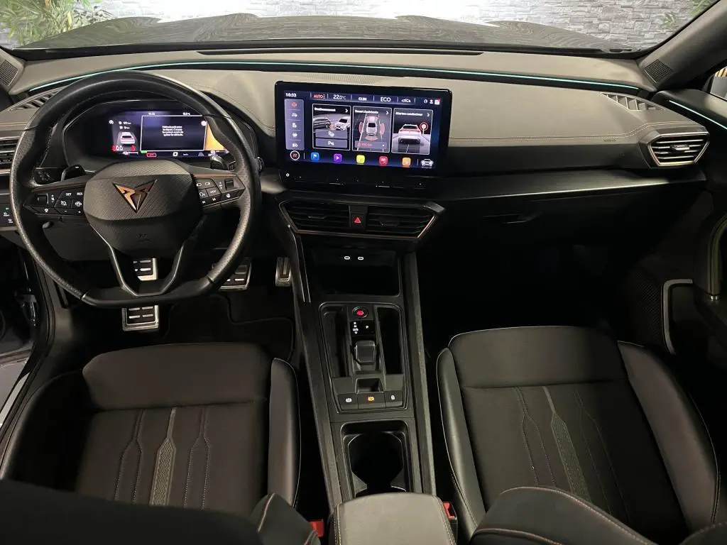 Intérieur avant du CUPRA Formentor 2023, vue du conducteur, tableau de bord noir avec écran tactile central et volant sport cuir.