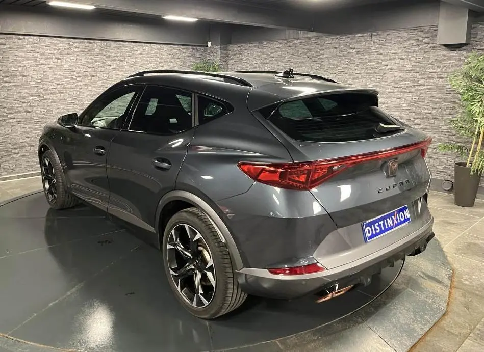 Vue 3/4 arrière droite du CUPRA Formentor gris magnétique 2023 avec feux arrière LED en bandeau et double sortie d'échappement copper.