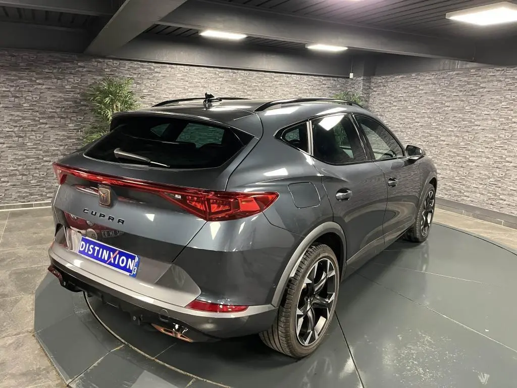 Vue 3/4 arrière droite du CUPRA Formentor gris magnétique 2023 avec feux LED reliés et jantes alliage noires.