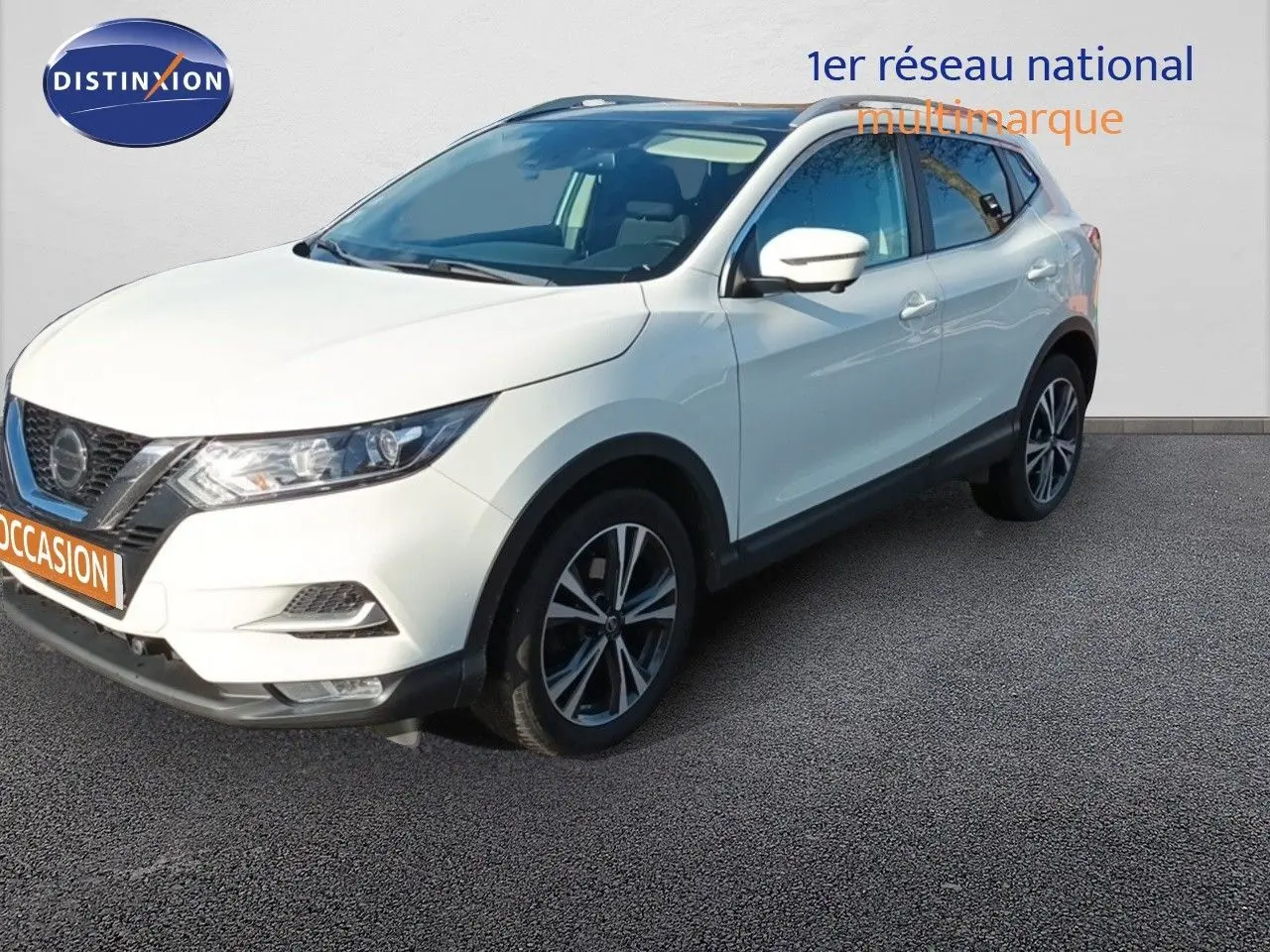 Nissan Qashqai blanc en 3/4 avant droit, avec jantes alliage bicolores et calandre distinctive noire.
