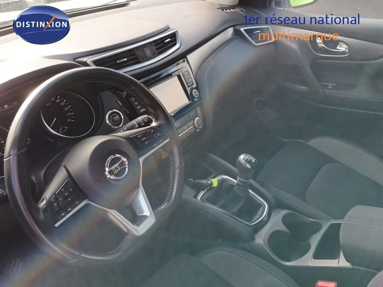 Intérieur noir du Nissan Qashqai 2018, vue sur le volant, tableau de bord et levier de vitesse manuel.