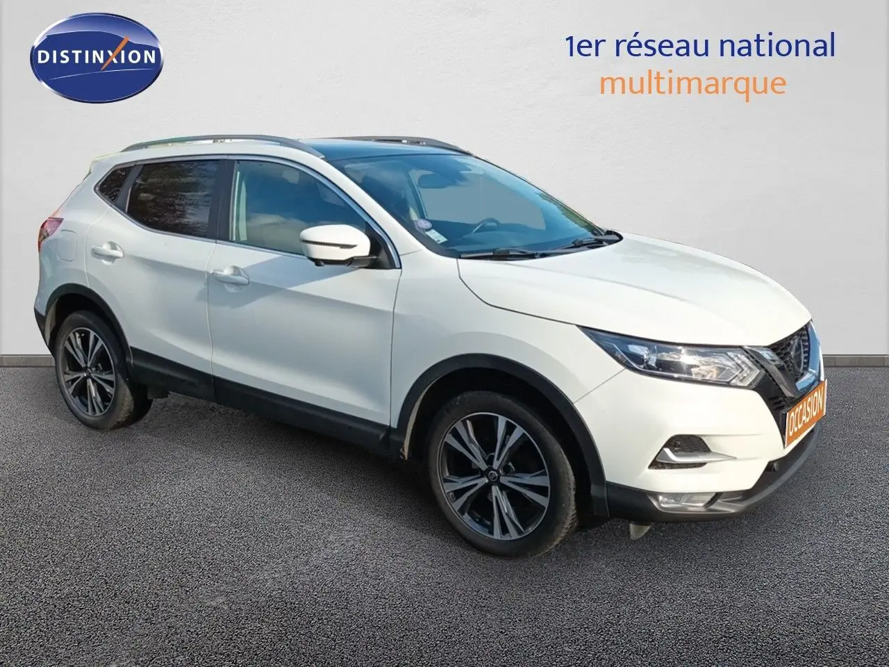Nissan Qashqai blanc en 3/4 avant droit, avec jantes alliage bicolores et vitres teintées.