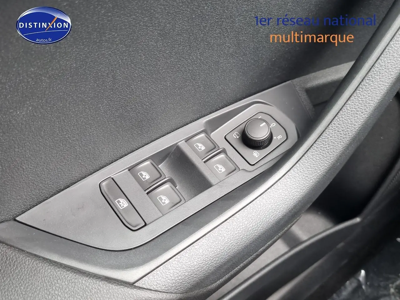 Gros plan sur les commandes des vitres et rétroviseurs côté conducteur d’un Skoda Karoq noir 2025.