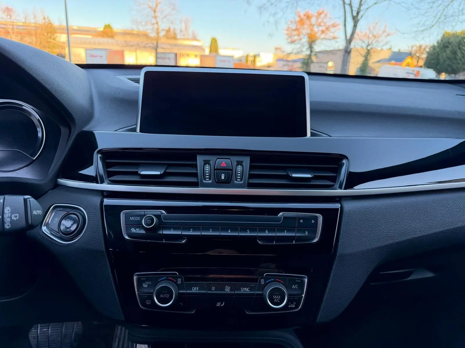 Vue intérieure centrée sur la console centrale du BMW X1 18D M Sport 2018 avec écran tactile et commandes de climatisation.