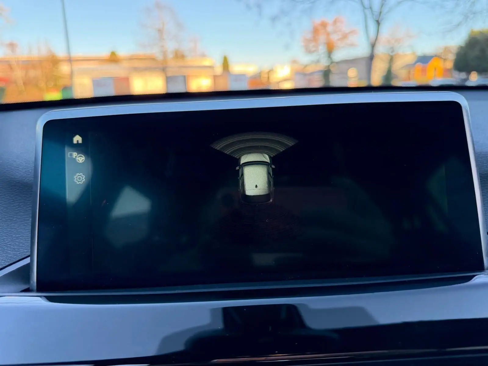 Écran central du BMW X1 18D 2018 montrant l’alerte de proximité avec vue stylisée du véhicule en blanc.