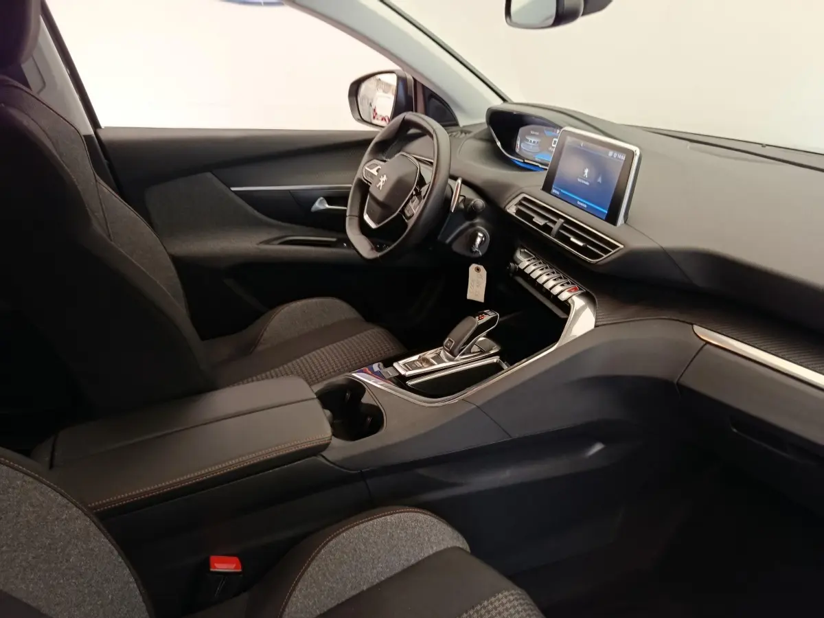 Intérieur de la Peugeot 5008 gris foncé, vue côté conducteur, tableau de bord avec écran tactile et volant multifonctions.