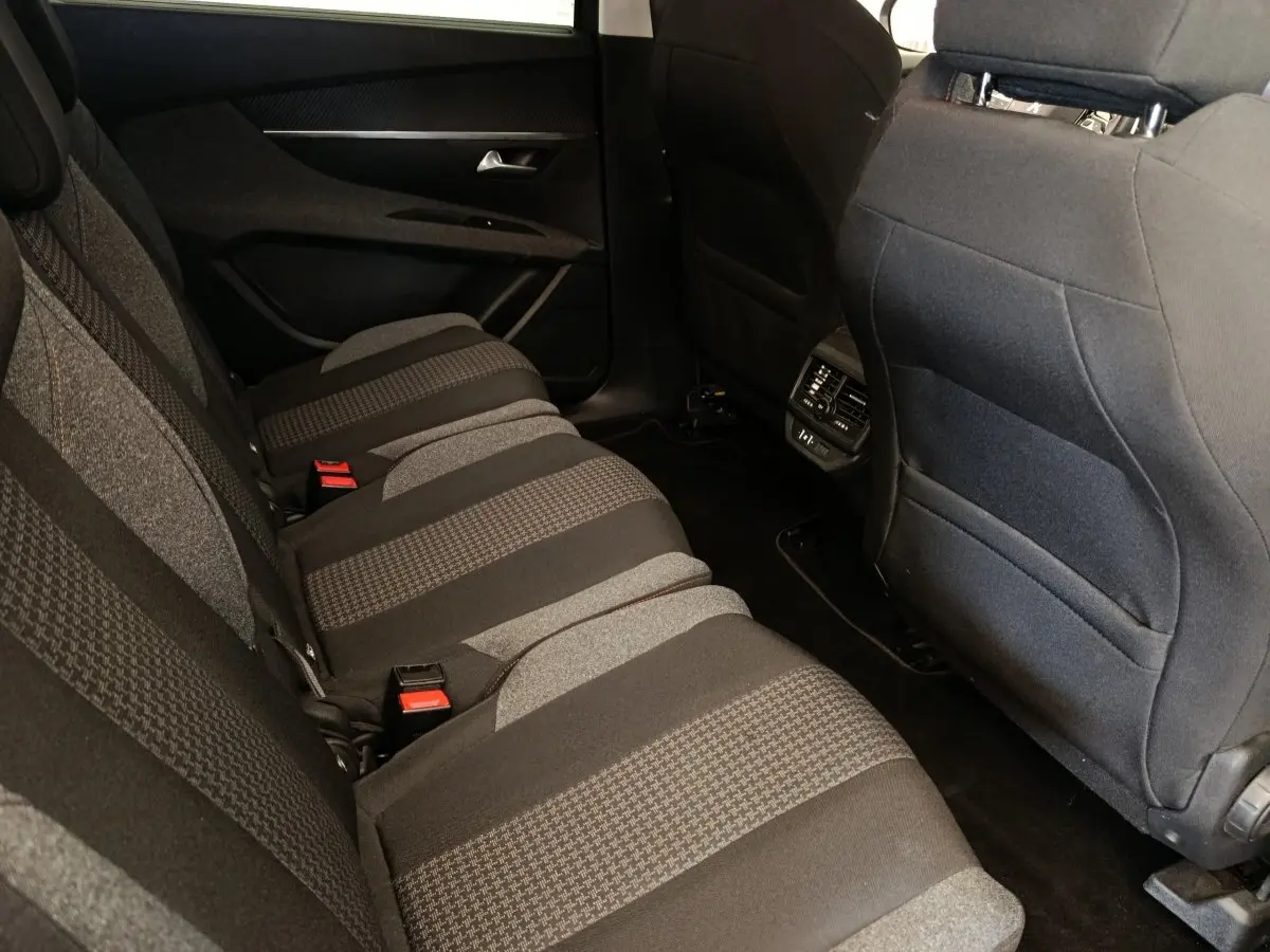 Vue intérieure côté droit des sièges arrière gris foncé à motifs du Peugeot 5008 avec commandes de climatisation au centre.