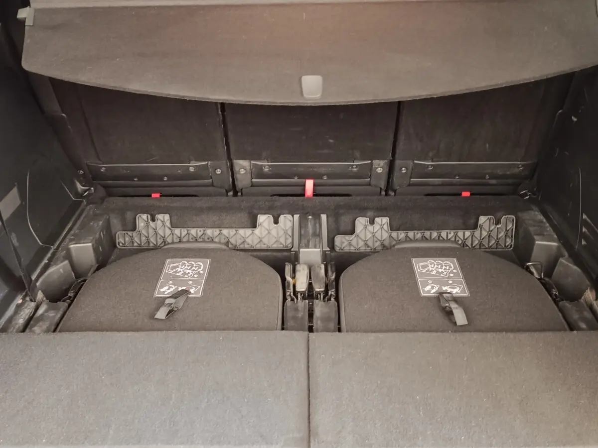 Vue intérieure du coffre du Peugeot 5008 gris foncé, montrant la 3ème rangée de sièges rabattus et le plancher plat.