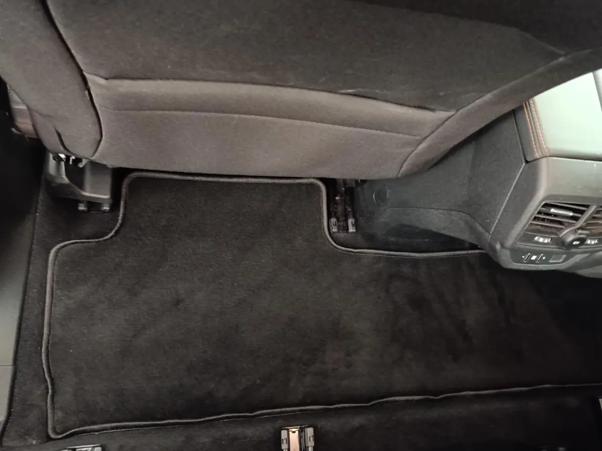 Vue intérieure du plancher arrière côté droit du Peugeot 5008 gris foncé avec tapis de sol noir et aérateurs arrière.