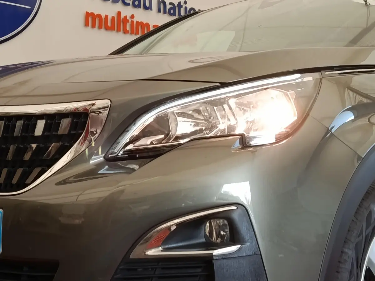 Gros plan sur l'avant droit gris foncé du Peugeot 5008 2020 avec phare allumé et calandre chromée.