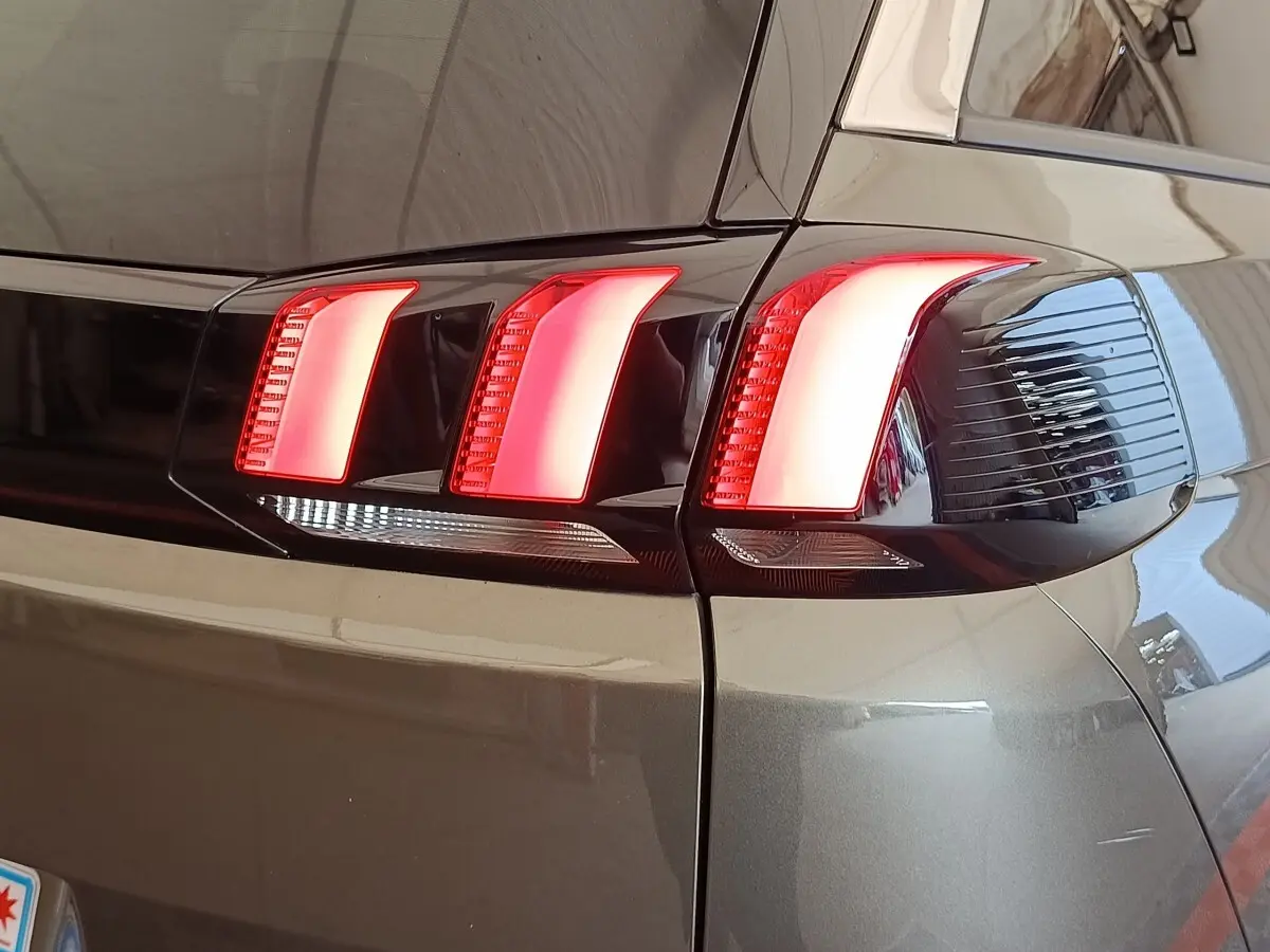 Gros plan sur le feu arrière droit rouge et blanc du Peugeot 5008 gris foncé, version 2020.