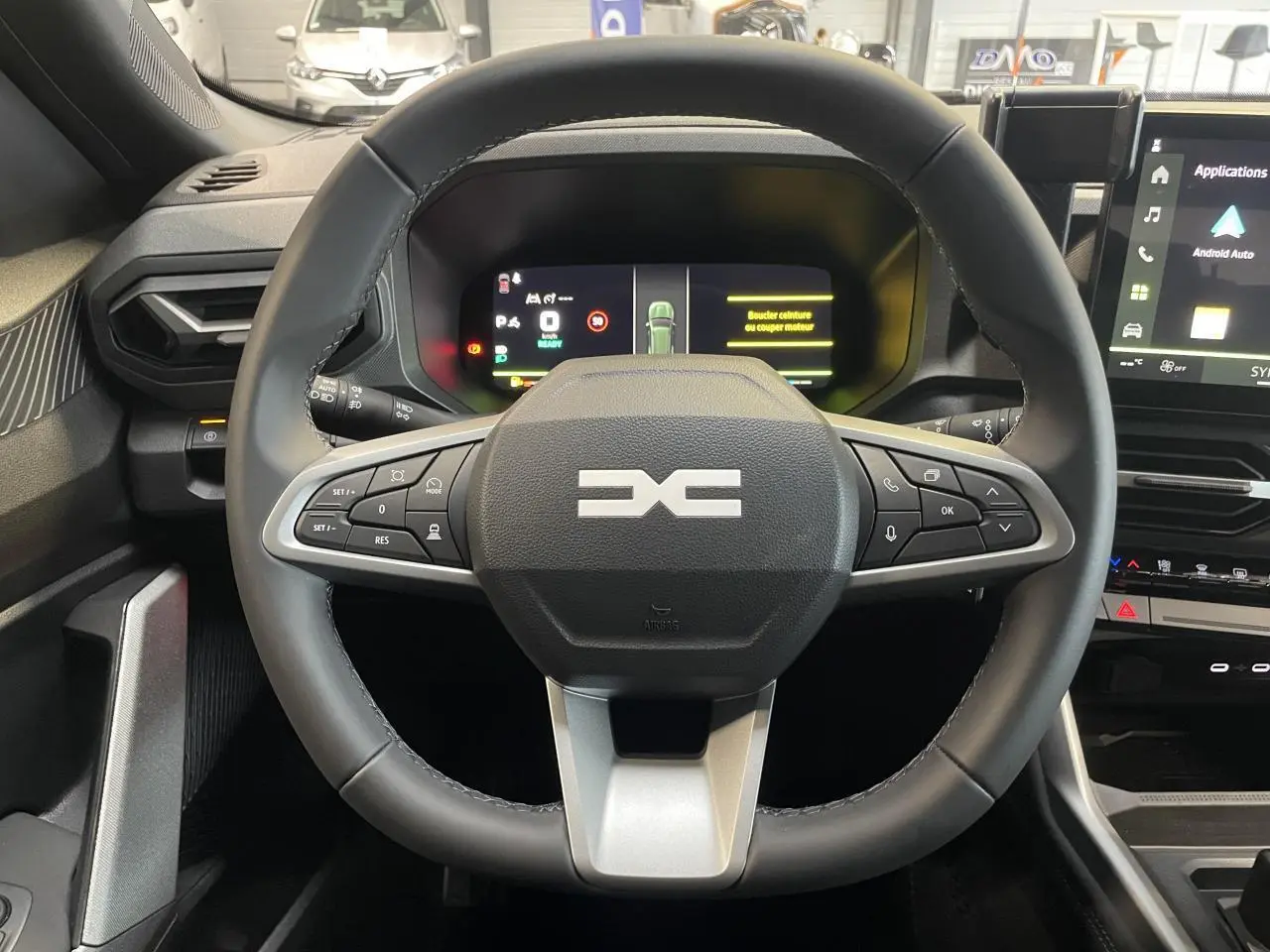 Vue intérieure centrée sur le volant noir du Dacia Bigster 2026 avec tableau de bord numérique et écran tactile latéral.
