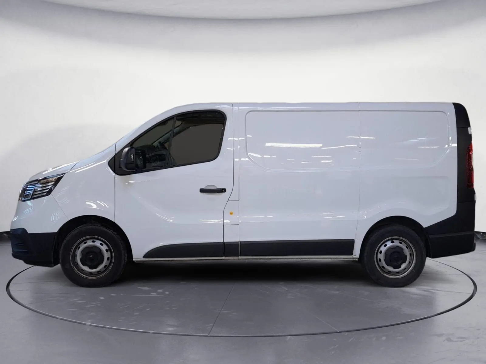 Vue de profil côté gauche du Renault Trafic Fourgon blanc minéral 2024 avec détails noirs sur bas de caisse et roues acier.