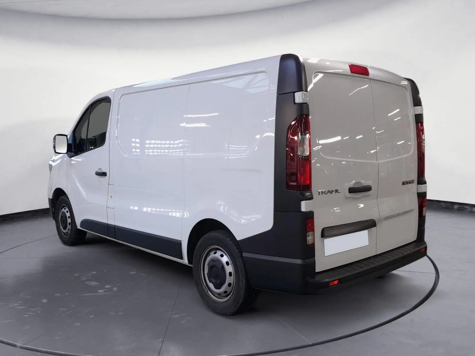 Vue 3/4 arrière droite du Renault Trafic Fourgon blanc minéral, avec portes arrière fermées et détails noirs contrastants.