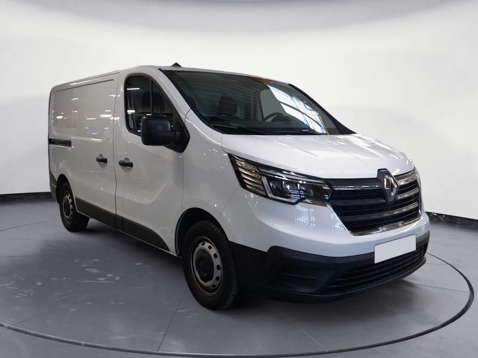 Renault Trafic Fourgon blanc minéral vu en 3/4 avant droit, avec calandre noire et jantes acier simples.