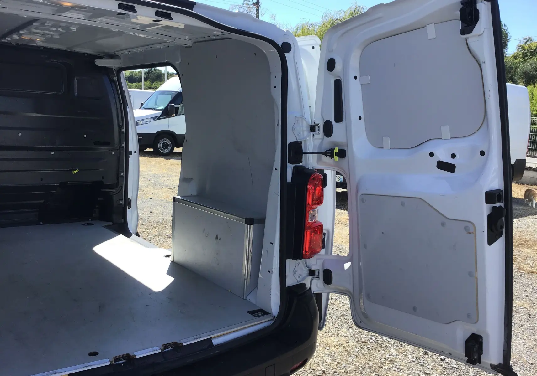 Vue arrière ouverte côté droit d'un Opel Vivaro blanc 2023, montrant l'espace de chargement vide et la porte arrière ouverte.