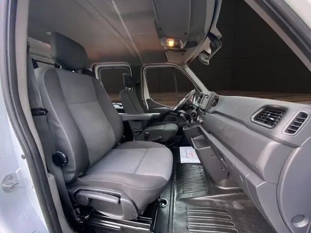 Vue intérieure côté conducteur du Renault Master Double Cabine 2022, sièges tissu noir et tableau de bord gris.