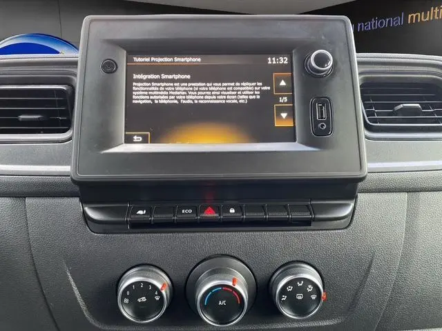 Vue rapprochée de l’écran tactile central et des commandes de climatisation du tableau de bord du Renault Master blanc de 2022.