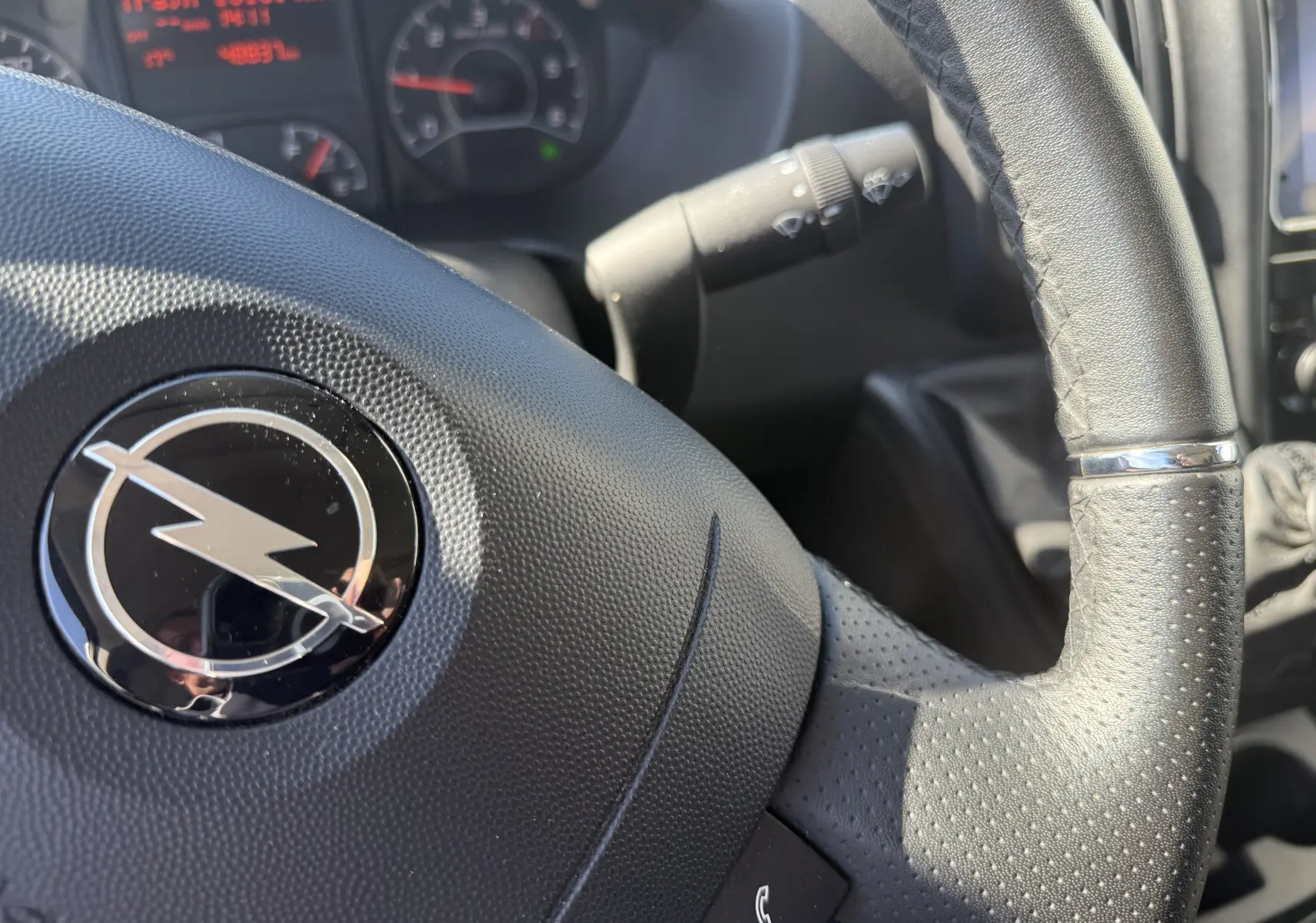 Gros plan sur la roue avant droite d’un Opel Movano Fourgon blanc 2023 avec jante acier et logo Opel au centre.