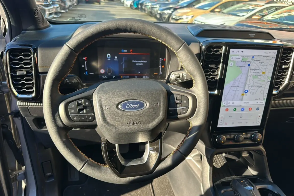 Vue intérieure centrée sur le volant cuir multifonctions et l'écran tactile vertical du Ford Ranger 2025.