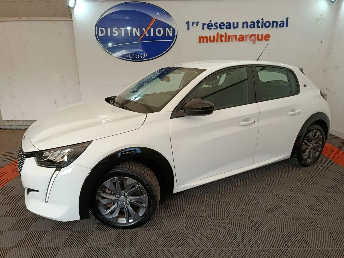 Peugeot 208 électrique blanche vue de 3/4 avant droit, avec rétroviseurs noirs et jantes gris foncé.