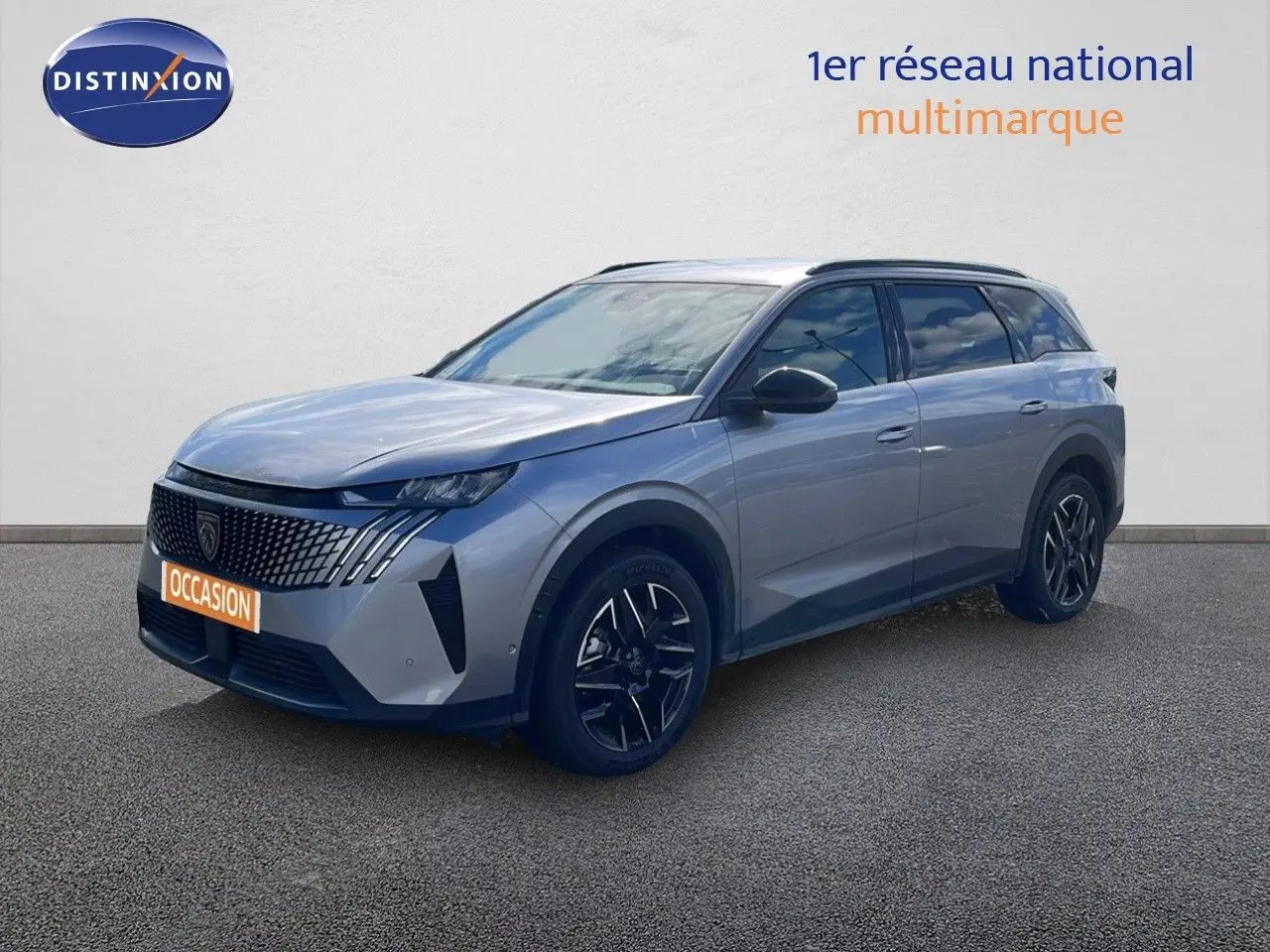 Peugeot 5008 Hybrid gris Artense métal en 3/4 avant droit, avec calandre distinctive et jantes noires bicolores.