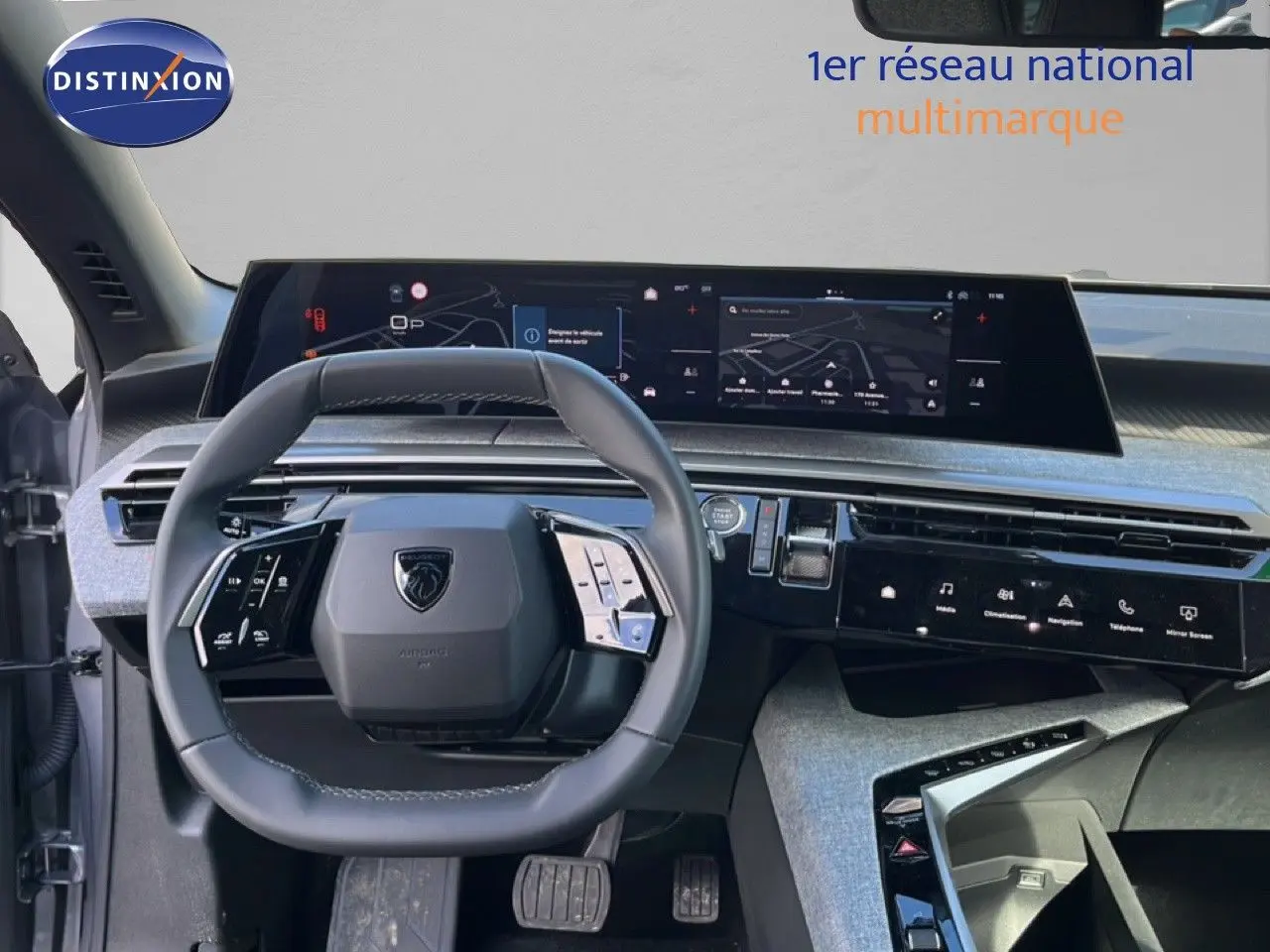 Vue intérieure du tableau de bord et volant cuir gris noir du Peugeot 5008 Hybrid 2025 avec écran tactile panoramique.