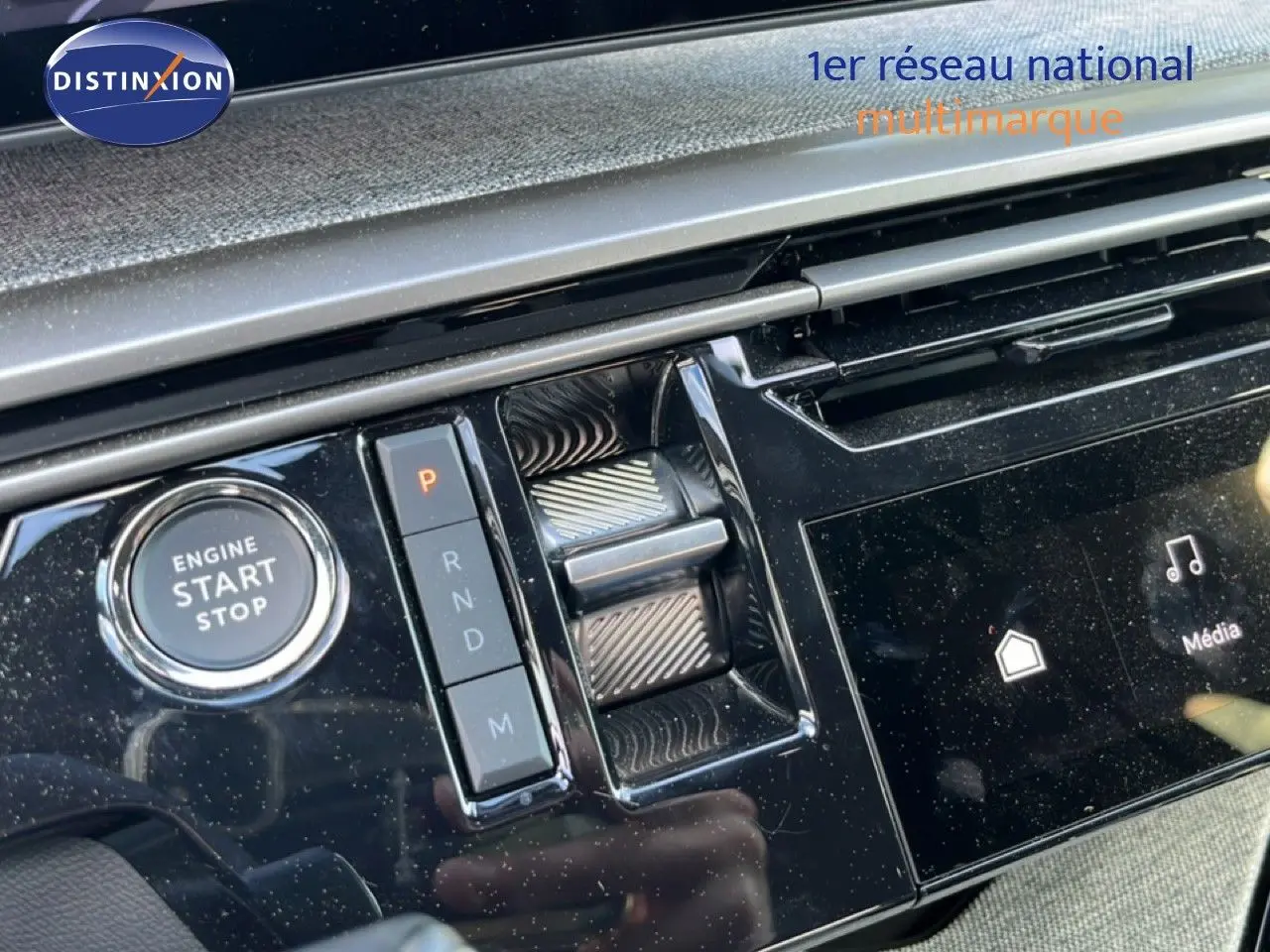 Gros plan sur la console centrale noire brillante du Peugeot 5008 gris, avec bouton start/stop et commande de boîte auto.
