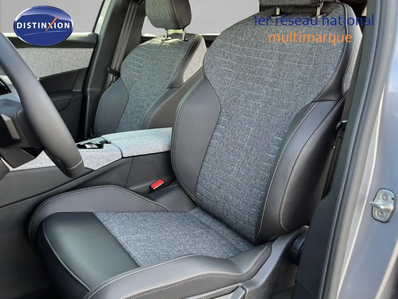 Vue intérieure côté conducteur du Peugeot 5008 Hybrid 2025, montrant les sièges gris tissu et cuir avec surpiqûres contrastantes.