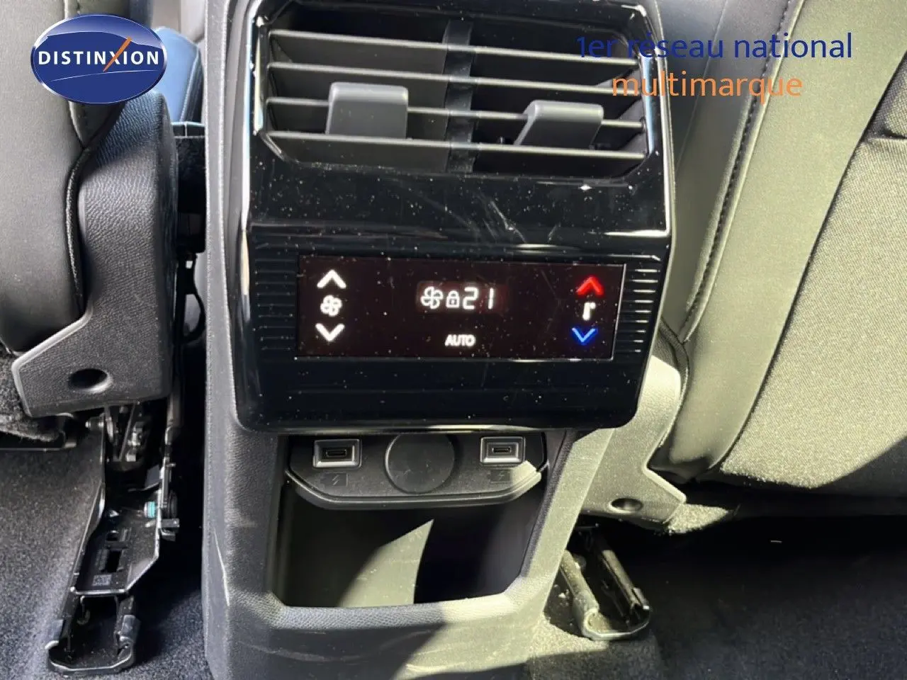 Détail de la console arrière du Peugeot 5008 gris Artense, avec commandes de climatisation et ports USB visibles.