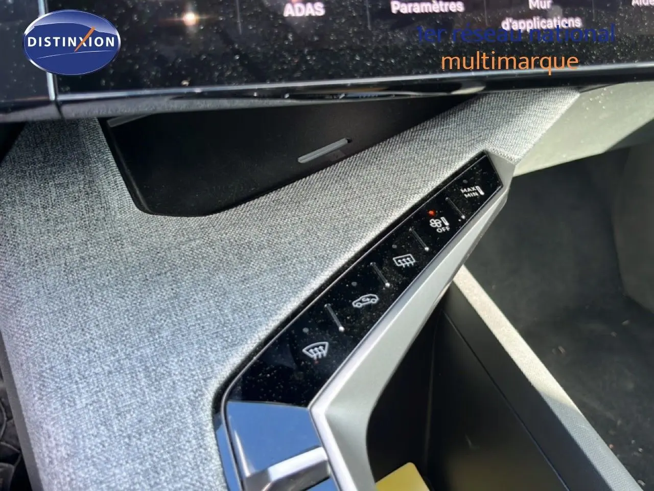 Vue rapprochée de la console centrale grise tissu du Peugeot 5008 Hybrid 2025, avec commandes tactiles et finition moderne.