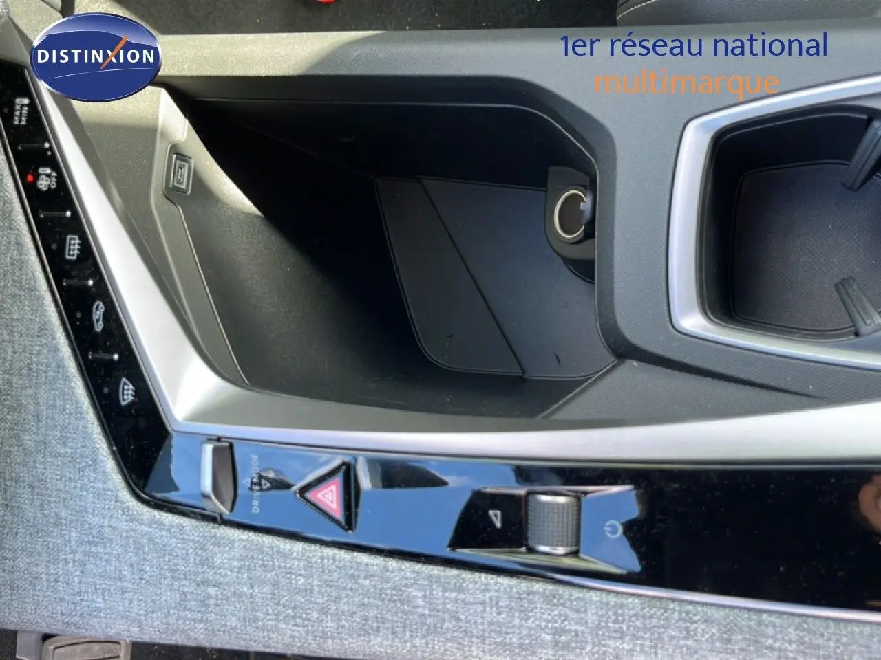 Gros plan sur la console centrale du Peugeot 5008 gris Artense, montrant les commandes de sécurité et un rangement.