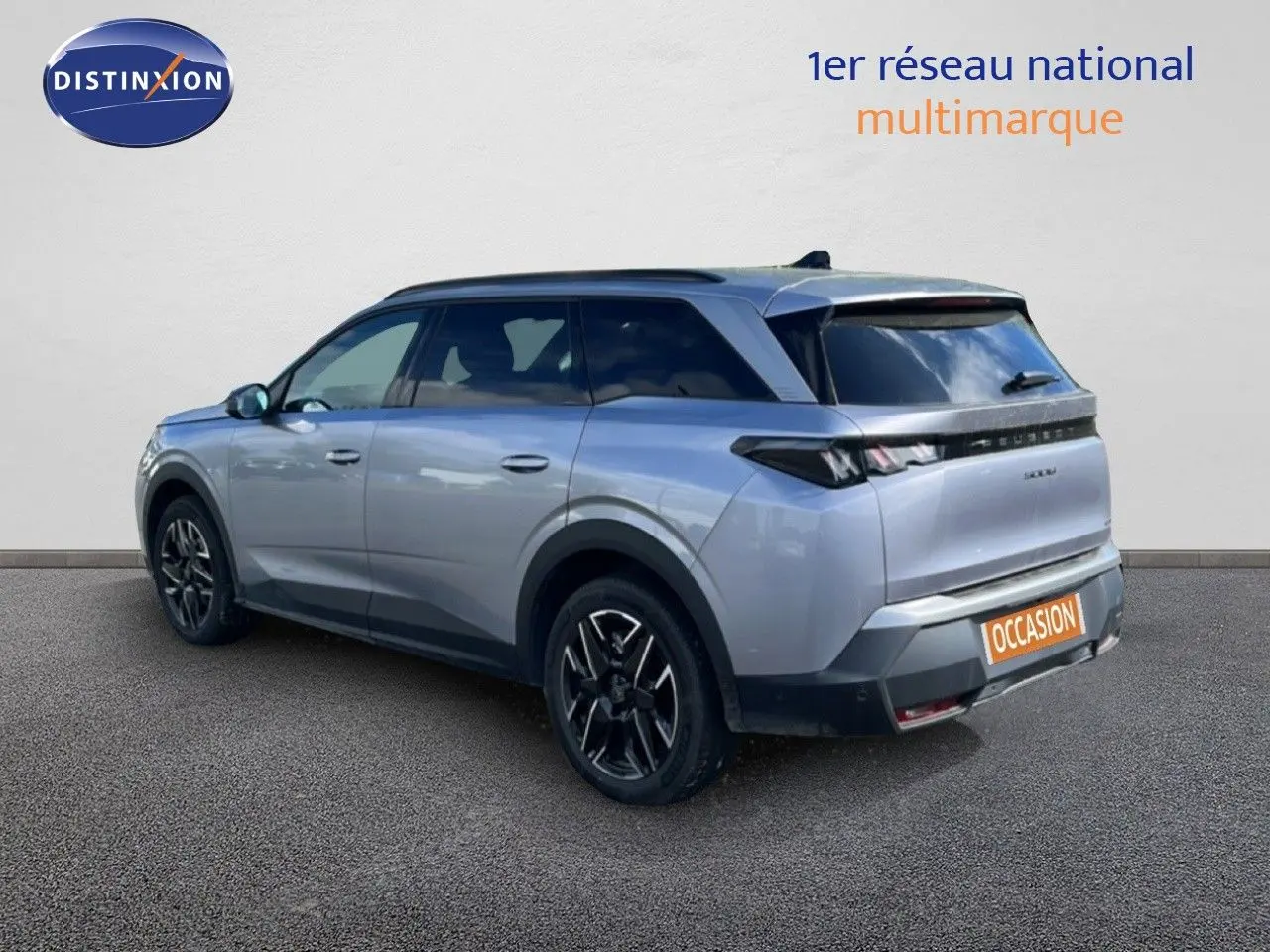 Peugeot 5008 Hybrid gris Artense métal, vue 3/4 arrière droit, jantes noires et toit panoramique visible.