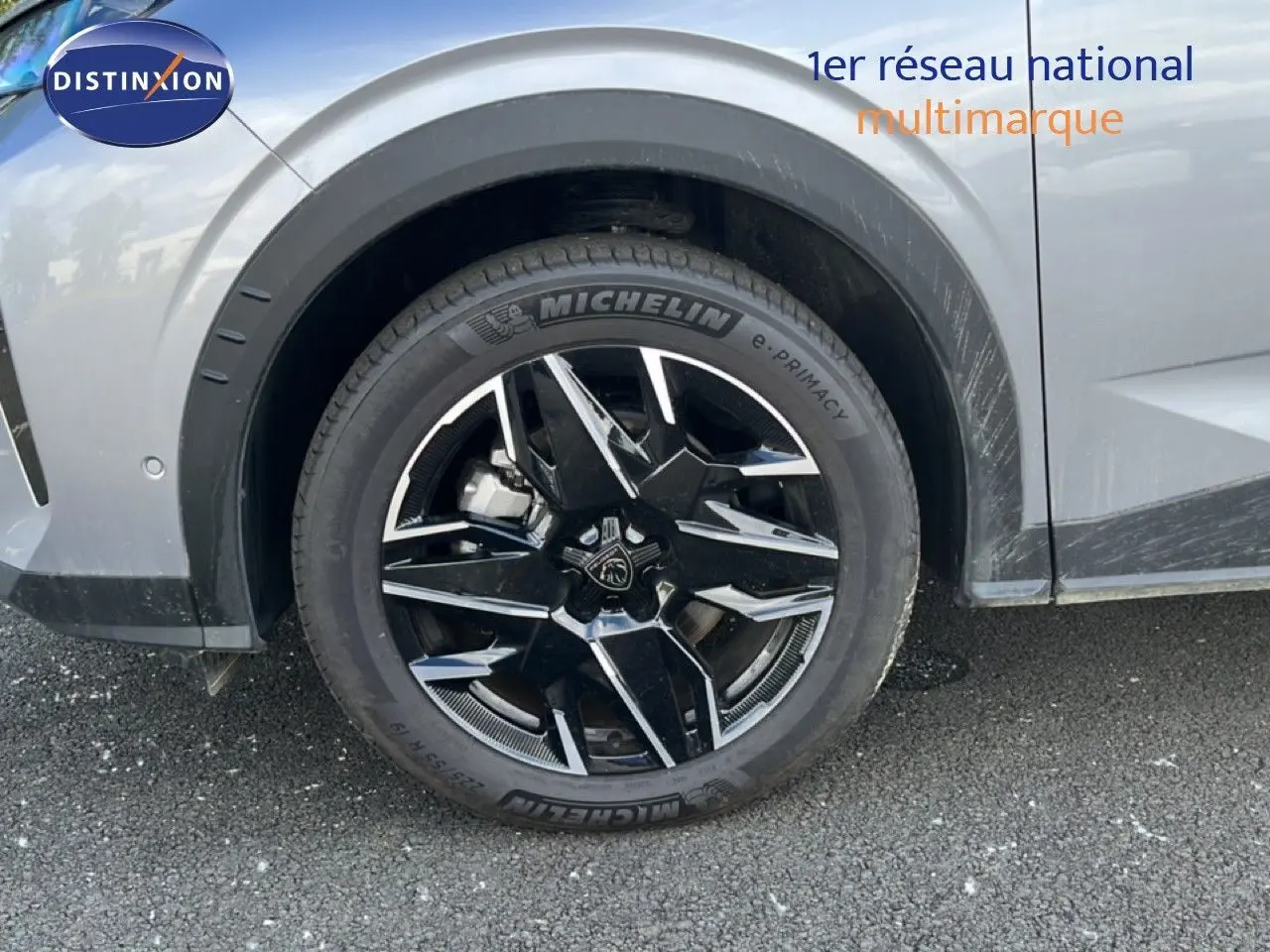 Gros plan sur la roue avant droite d’un Peugeot 5008 gris Artense métal avec jante noire et argentée au design moderne.