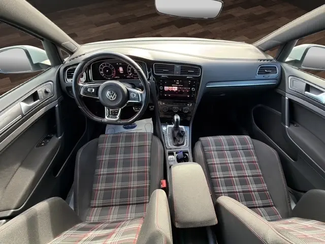 Vue intérieure avant de la Volkswagen Golf GTI Performance 2019, volant cuir alu multifonctions et sièges à motif tartan rouge et gris.