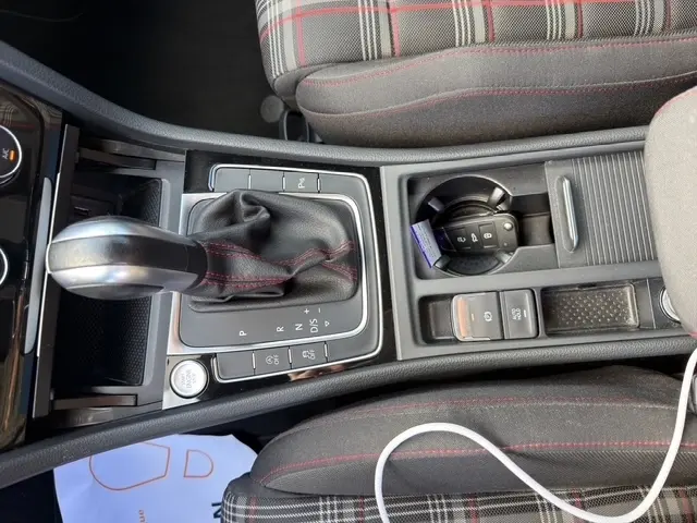 Vue rapprochée de la console centrale de la Volkswagen Golf GTI Performance 2019 avec levier de vitesse DSG et clé dans porte-gobelet.