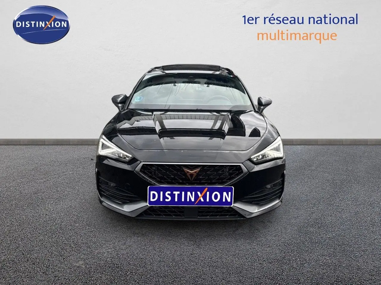 Vue frontale d'une CUPRA LEON ST noire Midnight Metal avec calandre distinctive et phares LED allumés.